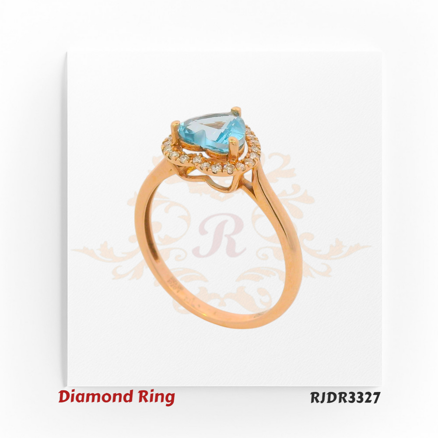 Delicate 18kt rose gold ring showcasing a heart-shaped blue topaz at the center, surrounded by a sparkling diamond halo – RJDR3327.