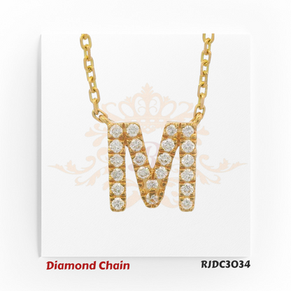 Stylish yellow gold diamond chain featuring a bold pendant in the shape of the letter "M", fully studded with shimmering round-cut diamonds. The pendant hangs from a classic gold link chain, set against a white background with a subtle royal crown and floral pattern. Model number RJDC3034 is noted at the bottom.
