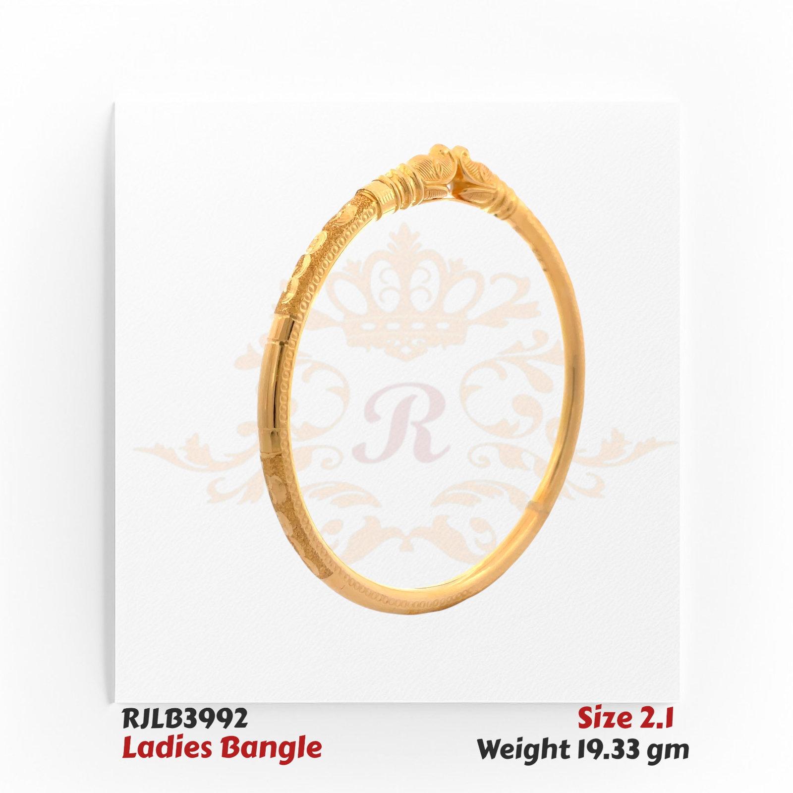 Angled view of a gold ladies bangle featuring an ornate central motif with layered scrollwork, subtle floral engravings, and fine detailing along the band for an elegant traditional touch. Model RJLB3992.