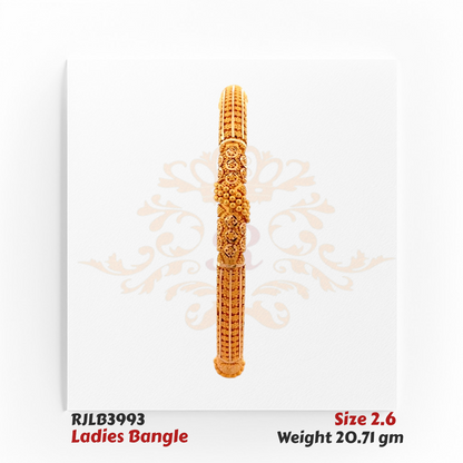 Front view of a gold ladies bangle adorned with intricate floral and swirl engravings, highlighted by a raised dome cluster centerpiece and finely textured segments for an ornate traditional look. Model RJLB3993.