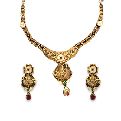 Traditional 22kt gold antique necklace set featuring detailed peacock motifs, floral Kundan work, and gemstone drops. Paired with matching earrings, perfect for bridal and festive occasions from Regal Jewels Chicago.