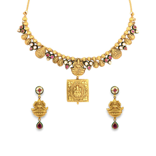 Divine 22kt gold temple-style necklace set featuring embossed Lakshmi motifs, intricate Kundan and ruby detailing, and matching earrings. A perfect choice for bridal, festive, and traditional wear from Regal Jewels Chicago.