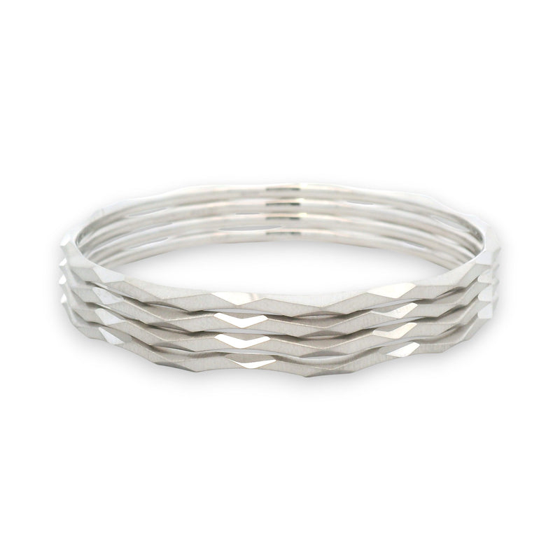 Four platinum bangles stacked together with a faceted, wave-textured finish, shown in an angled perspective highlighting shine and texture.